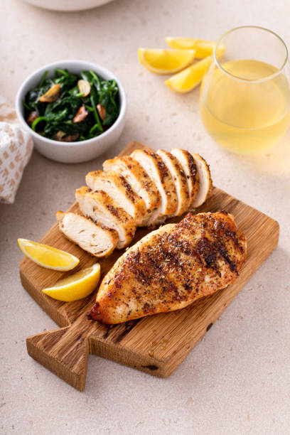 istock Grilled chicken breast, whole and sliced on a cooking board 1968568423