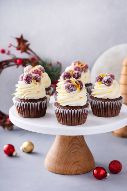 istock Festive chocolate and orange cupcakes with white chocolate frosting garnished with sugared cranberry 1968568434