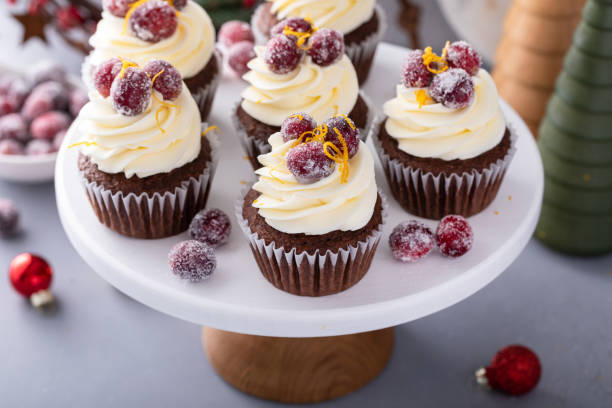 istock Festive chocolate and orange cupcakes with white chocolate frosting garnished with sugared cranberry 1968568435