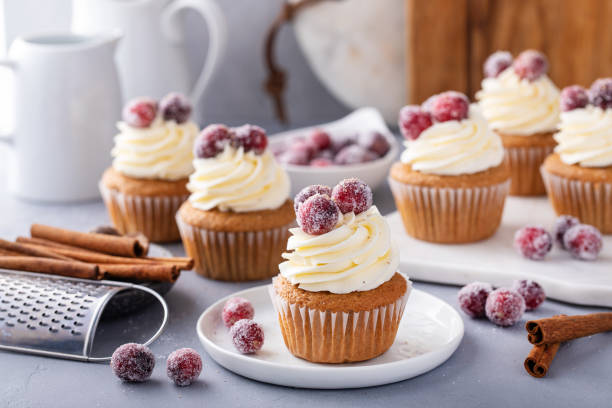 istock Spiced cinnamon and cranberry cupcakes topped with sugared cranberries for Christmas or Thanksgiving 1968568449