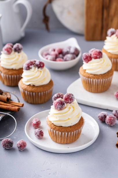 istock Spiced Christmas cupcakes with cream cheese frosting with sugared cranberries 1968568450