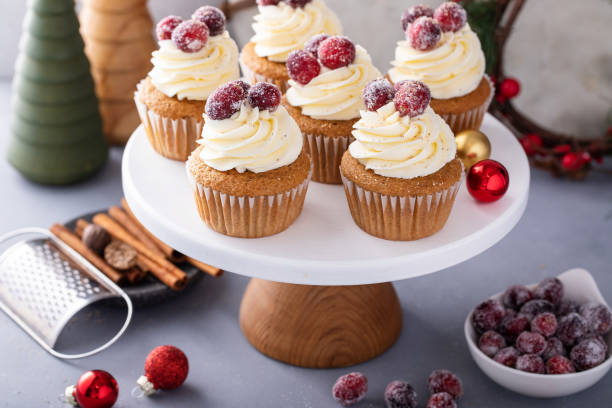 istock Spiced Christmas cupcakes with cream cheese frosting with sugared cranberries 1968568457