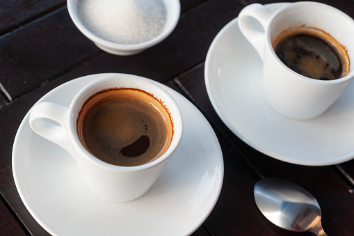 two single and double cups of espresso coffee are placed on the table