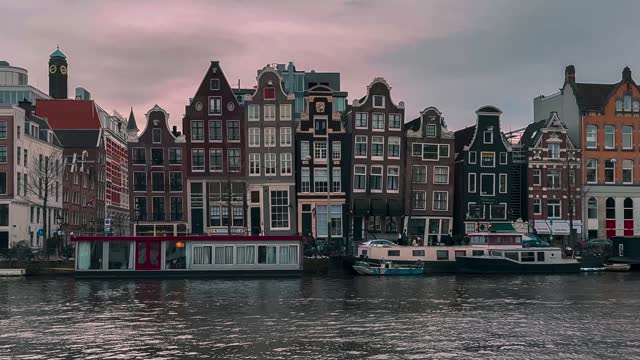 Traditional old narrow houses boats and canals in Amsterdam, Netherlands, Europe, January 20, 2024