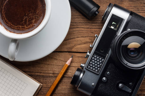 istock Film photo camera, cup coffee, notepad on desk 1968772083