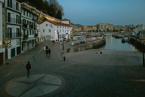 1st January 2024, San Sebastián，Basque Country, Spain: Locals and Tourists walking at harbor during dusk. San Sebastián is famous for its longest beach in Europe and incredible food culture.