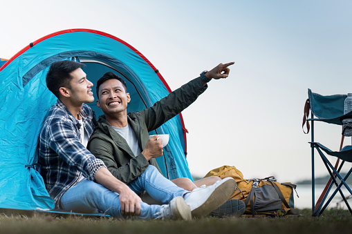 Happy Asian male gay couple on camping together in a forest. romantic vocation trip. lgbt concept.