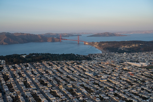 Aerial view of residential district, bay and bridge at twilight
