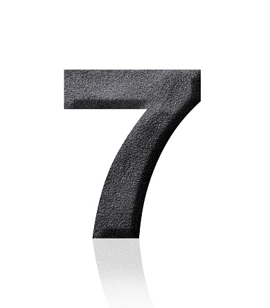 Close-up of three-dimensional black sand number 7 on white background.