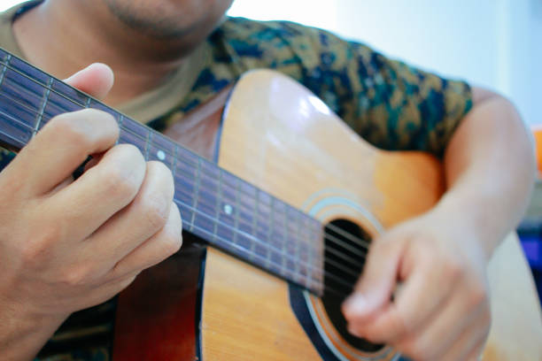 istock brown soldier playing guitar 1968886245