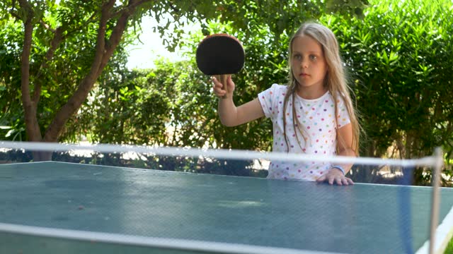 Pretty emotion girl play table tennis on green background