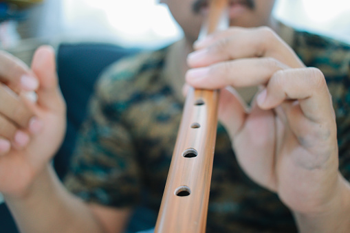 man play bamboo flute