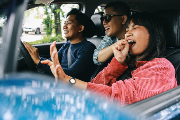Happy Diverse People Around Car Happy Young Friends During Road Trip, Girl Enjoy Singing Along The Trip happy car asian stock pictures, royalty-free photos & images