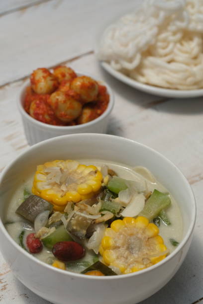 istock Sayur Lodeh is Indonesian traditional lunch menu, made from various chopped vegetables, coconut milk, and spices. Served in wooden bowl and wooden table. Indonesian food. 1968958668
