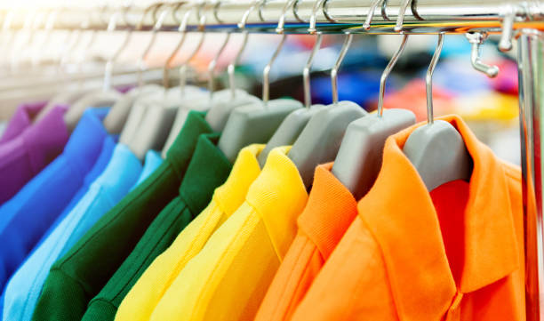colorful polo shirts on hangers in a row - polo shirt multi colored clothing variation - fotografias e filmes do acervo