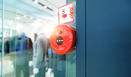 Manual push station of fire alarm system, installed on the wall of shopping center