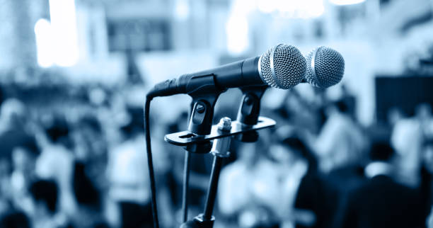 istock Closeup microphone in auditorium with blurred people in the background 1968968719