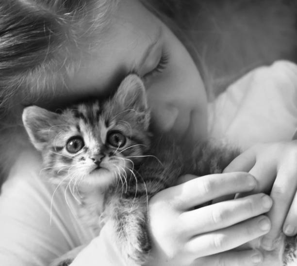 istock Black and white banner with child and kitten. Hugging lovely pets. 1968976053