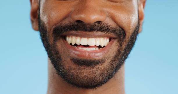 istock Smile, closeup and black man with teeth in studio, blue background and mockup space with happiness or advertising. Portrait, closeup and marketing for skincare, wellness or healthy dermatology care 1969010021