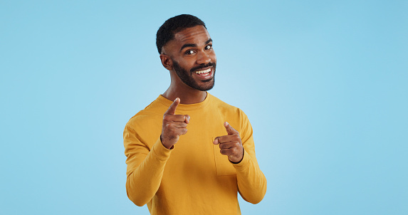 Face, excited and black man pointing at you for decision, choice or selection in studio isolated on a blue background mockup space. Portrait, hand gesture and person hiring, recruitment or invitation