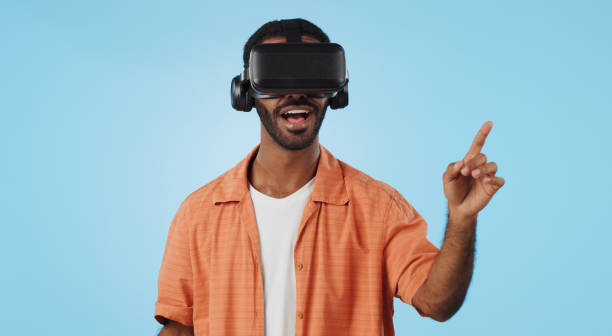 istock Man, virtual reality and glasses in studio with hand, click and swipe with smile for metaverse by blue background. Person, AR vision and futuristic game with 3D user experience, cyber ui and esports 1969011121