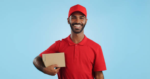 istock Happy man, box and delivery in transport service, package or order in studio against a blue background. Portrait of male person or courier guy smile with parcel, cargo or logistics on mockup space 1969011134