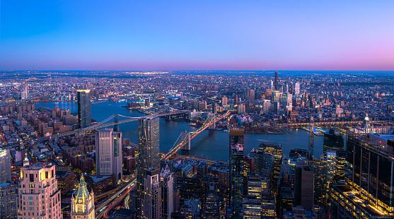 Helicopter point of view of New York City skyscrapers. Empire State building and many details are visible in the image. Sunset is in the background.