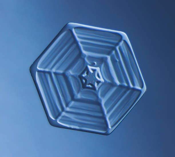 Natural snowflake crystal close-up macro photoNatural snowflake crystal close-up macro photoSnowflake on smooth gradient background grey to blue : macro photo of real snow crystal on glass surface. This is small snowflake with unusual pattern.