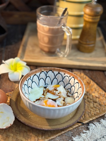 Perfect soft boiled egg in an bowl on the table. Traditional food for a healthy breakfast and kopitiam or Traditional oriental and vintage kopitiam breakfast style.