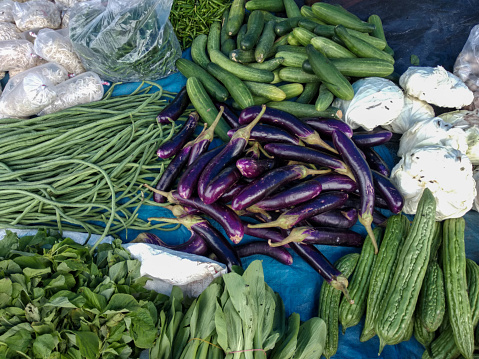 cucumbers, eggplants, bitter melons, spinach, long beans, and some other vegetables sold in the Indonesian traditional market. top-down view.