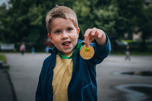 Cute little boy showing his first gold medal.