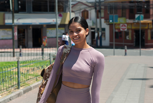 young latina from ecuador sightseeing alone with her backpack and a slight smile on her face. High quality photo