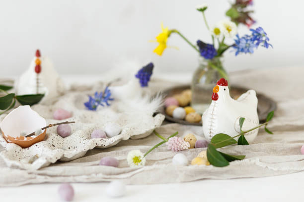 istock Happy Easter! Stylish easter chocolate eggs, spring flowers, chicken figurines and linen cloth on rustic wooden table. Space for text. Easter modern simple decoration 1969172841