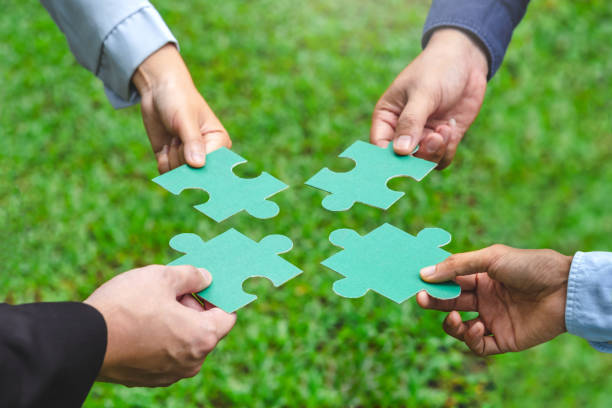 istock World environment day  and ESG Concept of teamwork and partnership Hands join Jigsaw puzzle pieces with global community sustainable Save Earth. the Environment World Earth Day concept 1969217973
