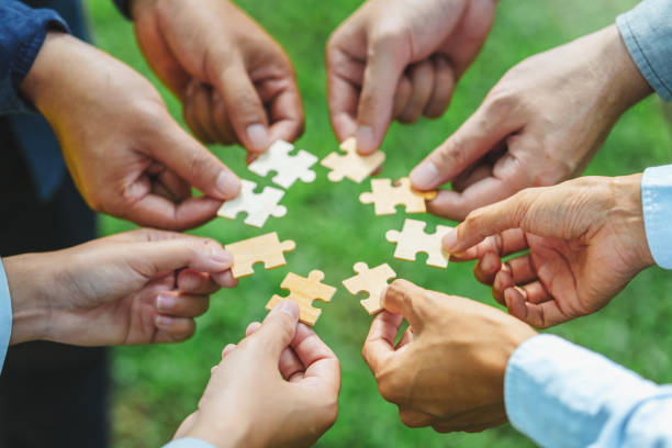 istock World environment day  and ESG Concept of teamwork and partnership Hands join Jigsaw puzzle pieces with global community sustainable Save Earth. the Environment World Earth Day concept 1969221184