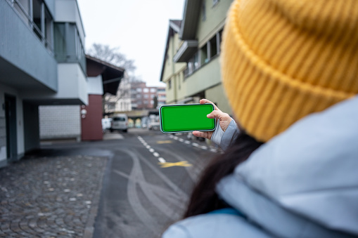 smartphone with green screen is in woman hand she is taking photo at street horizontal travel still