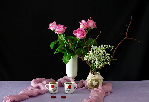 Valentine's Day decorations. Still life to day Valentine with cups of coffee and flowers on the table close-up