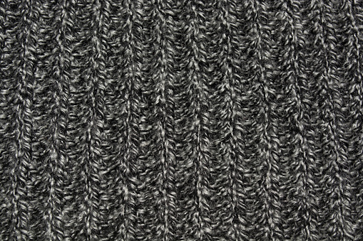 Background gray white knitted canvas. Texture of gray white knitted fabric