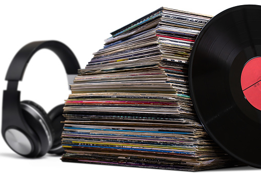 pile of old vinyl discs and headphones isolated on white background