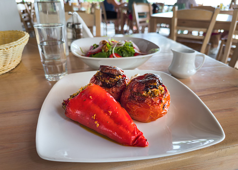 Traditional greek meal: Peppers and tomatoes stuffed with rice with mixed salad with dried fruits.