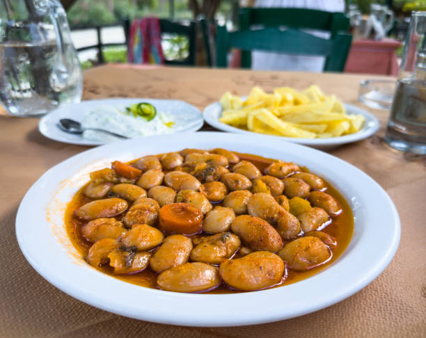Traditional greek food: giant beans in tomato sauce with fried potatoes and tzatziki.