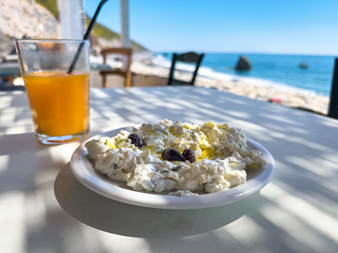 Traditional greek meal: tzatziki with view on the sea.