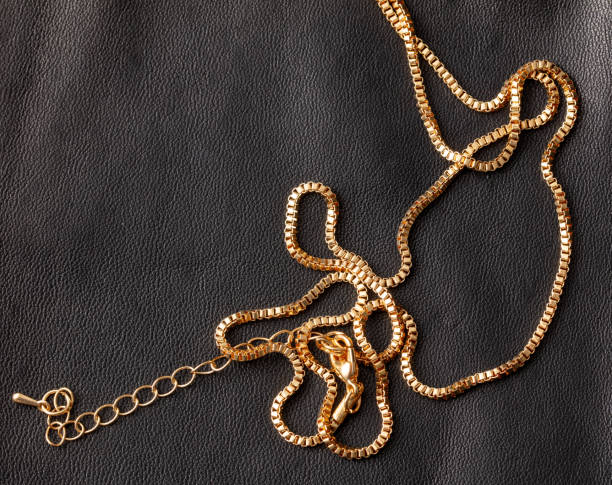 istock Gold chain on a black leather background 1969350510