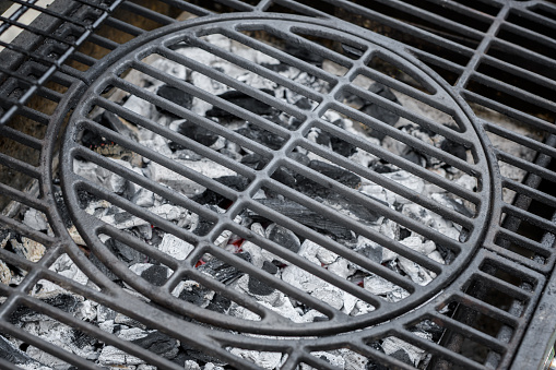 Grill grate close-up, gray ash from wood briquettes