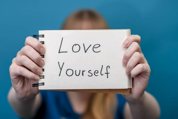 istock Girl holding a card with the affirmation love yourself 1969358021