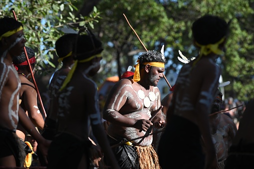 Laura, Qld - July 08 2023:Indigenous Australian man holding traditional weapons during a ceremonial dance in Laura Quinkan Dance Festival Cape York Australia. Ceremonies combine dance, song, rituals, body decorations and costumes
