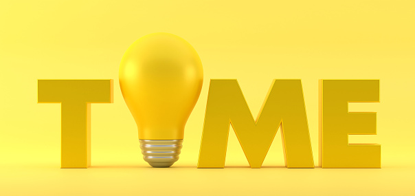 Time With Light Bulb On Yellow Background