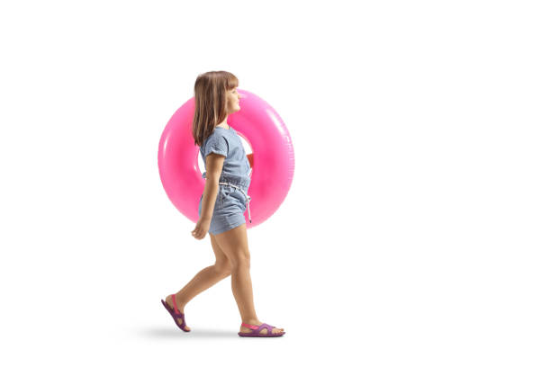 Child carrying a swimming ring and walking isolated on white background