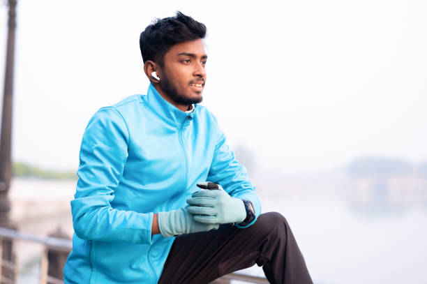 istock Happy athlete stretching his arms while having sports training in the park 1969392154