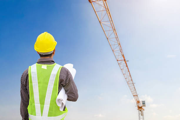 istock construction engineer worker in protective helmet and blueprints paper on hand at building site background 1969398236